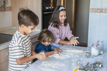 Three Adorable Children Having Fun In The Kitchen. Cute Mischievous 4 And 9 Year Old Child Playing With Flour And Making Mess After Rolling The Dough For Cookies On Kitchen Counter