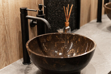 a dark wash basin with a black faucet