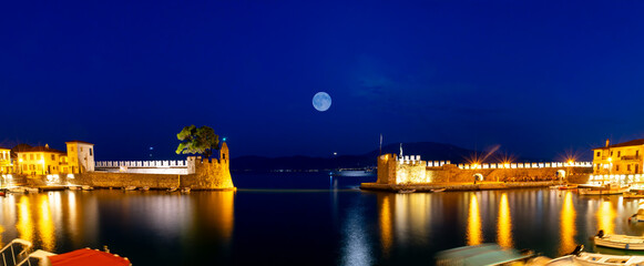 Panorama of Nafpaktos port during blue hour against the full moon.

