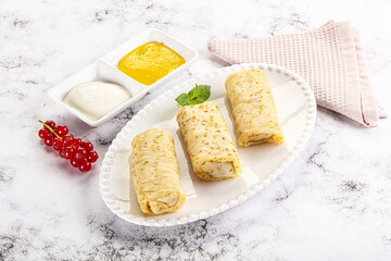 Homemade stuffed pancakes with honey and cream sour