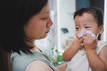 Asian woman brushing her teeth and washing her face with her child in the morning
