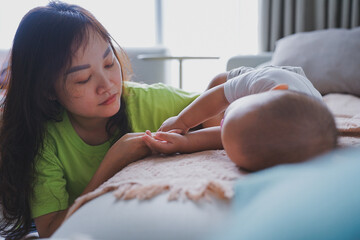 Young Asian Woman is rocking her baby to sleep
