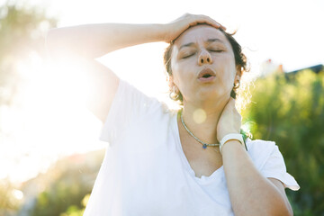 Young woman having hot flash and sweating in a warm summer day
