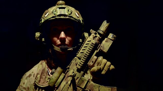 In the semi-darkness, she holds a rifle, preparing for the next step. The light falls on her face and weapon, emphasizing the determination and seriousness of the situation