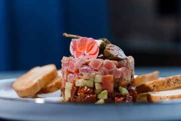Exquisite Tuna Tartare with Edible Flower Garnish and Toasted Slices on Elegant Plate