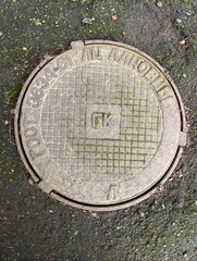 Obraz premium A manhole cover on the ground with a grid pattern on it