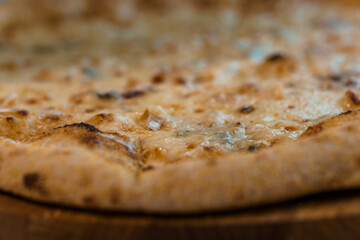 Close-Up of a Deliciously Golden-Brown Cheese Pizza Crust with Melted Cheese in a Rustic Setting