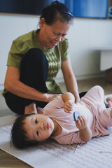 Asian grandmother takes care of her granddaughter at home
