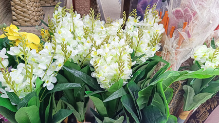 White and yellow Artificial freesia flowers on display at the flower market