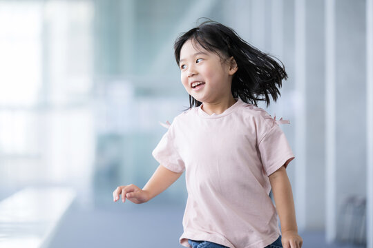 学校の校舎を走る歩く子供の明るいイメージ　振り返る