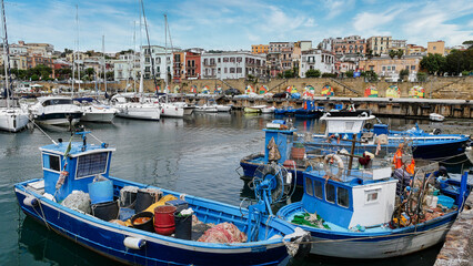 Obraz premium Diverse Boote im Hafen von Pozzuoli bei Neapel vor wunderschöner Altstadtkulisse