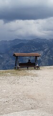Woman sitting on a bench in the mountains, Like a postcard
