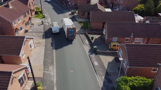 Drone 50fps. UK Waste collection truck in urban street. 