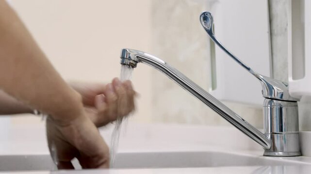 Close-up of a medical professional washing hands before surgery. Highlights crucial hygiene practices and meticulous preparation for maintaining a sterile environment.