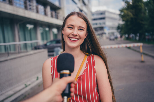 Photo of lovely pretty woman giving interview to journalist speaking in microphone public asking outdoors