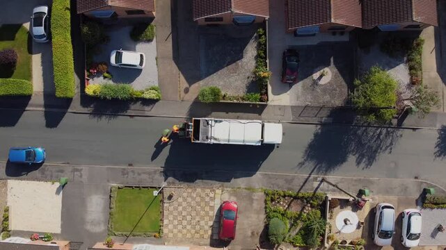 Drone 50fps. UK Waste collection truck in urban street. 
