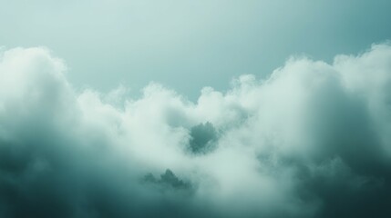 Fototapeta premium Soft, white clouds drift across a blue sky.