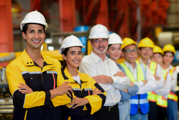 Portrait of group diversity workers industrial team, Manager, Engineers, and technicians wearing safety uniform workwear standing cross arms look confident in an industrial manufacturing factory.