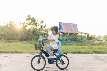 A young girl is riding a bicycle with a basket on the front
