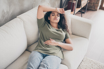 Photo of unhappy upset woman dressed green t-shirt lying couch feeling headache indoors house...