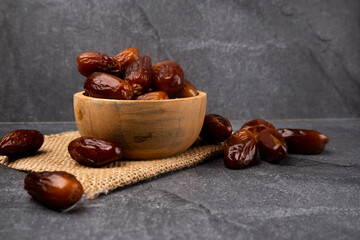 Dried date fruits in wooden bowl