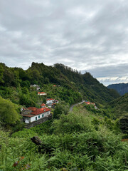 Obraz premium Hiking mountain trail among rocks and plants with a view of the clouds and gorge