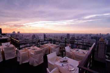 Table setting on roof top restaurant with megalopolis view, Bangkok Thailand.