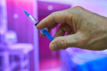 hand holding syringe for vaccinating patient