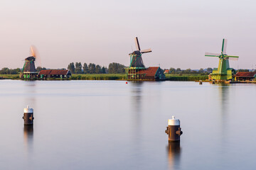 Fototapeta premium Long exposure shot of Dutch windmills along the Zaanse Schans in Zaandijk, Netherlands