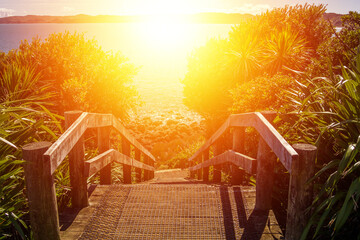 Coastal path with wooden steps down to the rocky coastline. Bright light beckoning and promising...