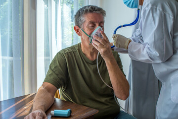 Oxygen face mask is placed on a man with breathing difficulty due to his lung disease. Covid-19,...
