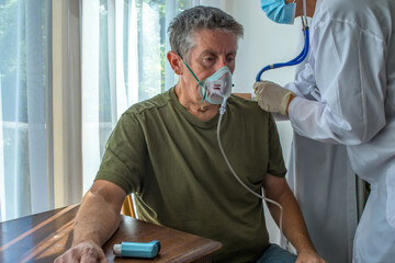 Oxygen face mask is placed on a man with breathing difficulty due to his lung disease. Covid-19,...