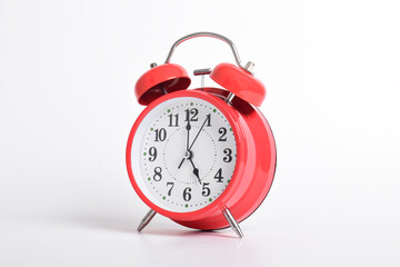 Red alarm clock set at five o'clock isolated on white background. Close-up with clipping path
