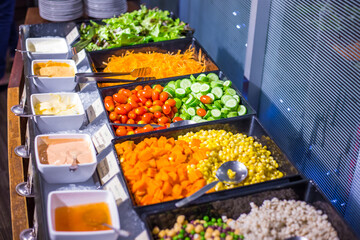 Colorful fresh vegetable salad bar with homemade sauces dressing