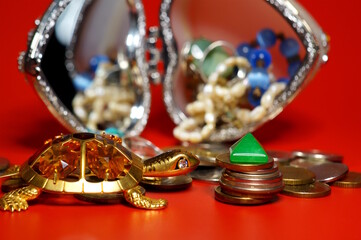 A turtle statuette with coins and a green pyramid.