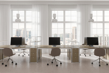 Cozy coworking interior with pc computers and tables in row near window