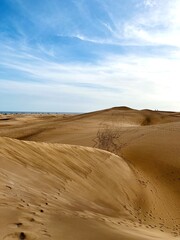 Minimalist photography of golden dunes against a bright blue sky next to the ocean. Dunas Maspalomas Gran Canaria, Spain