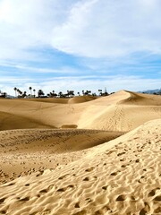 Minimalist photography of golden dunes against a bright blue sky next to the ocean. Dunas Maspalomas Gran Canaria, Spain