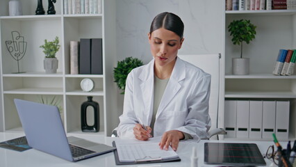 Medical professional concentrating documentation analysis in hospital office.