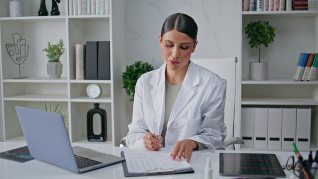 Medical professional concentrating documentation analysis in hospital office.