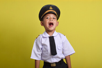 Little Asian boy Airplane pilot isolated on yellow background. Little boy dreams of becoming an airplane pilot.