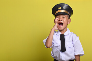 Little Asian boy Airplane pilot isolated on yellow background screaming with mouth wide open....