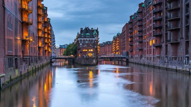 Hamburg, Germany. Night view of Speicherstadt in Hamburg, Germany. Time-lapse with illuminated historical buildings at sunset with reflection in the water, panning video
