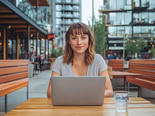 Fototapeta premium Casual Woman Working Outdoors on Laptop at Trendy Street Furniture