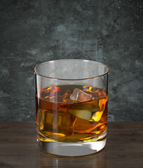 Glass of cognac on the wooden table against the wall in grunge style. Bar theme. Dark environment. 3d rendering.