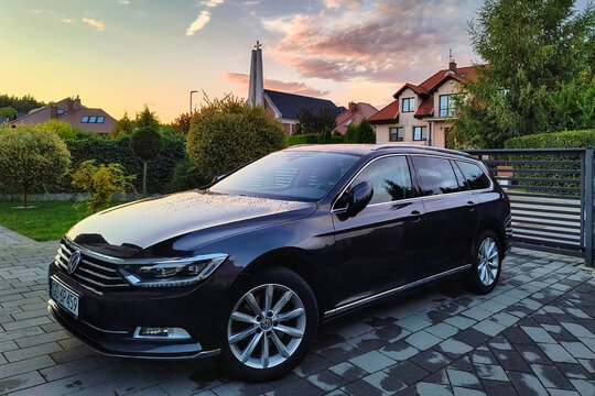 Gdansk, Poland - August 18, 2024: Front view of the Volkswagen Passat B8 car parked next to the house at sunset.