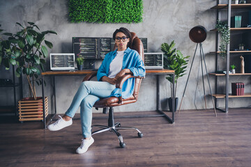 Full length photo of lovely young lady work boss sit armchair dressed blue shirt comfortable programmer startup office loft room interior