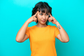 Young Argentinian woman isolated on blue background having doubts and thinking