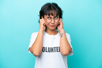 Young volunteer Argentinian woman isolated on blue background frustrated and covering ears