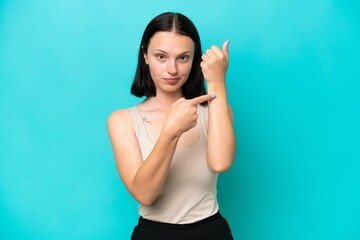 Young caucasian woman isolated on blue background making the gesture of being late